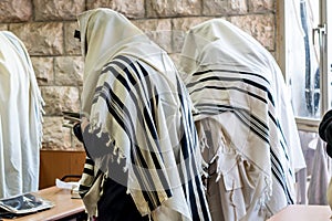 Jewish men praying in a synagogue with Tallit photo