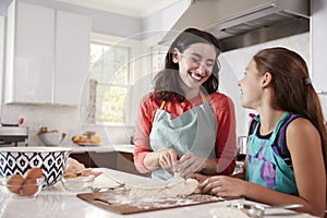 Jewish mother and daughter plaiting dough for challah bread