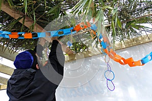 Jewish Orthodox man decorating a Sukkah