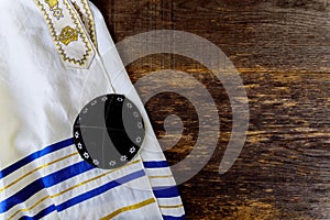 Jewish prayer items tallit and kippa on a wooden table photo