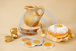 Jewish religious holiday Hanukkah with donut, wooden dreidel, oil jug, candles. Golden baner