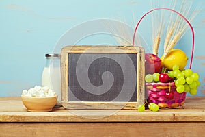 Jewish Shavuot background with chalkboard, milk and fruit basket