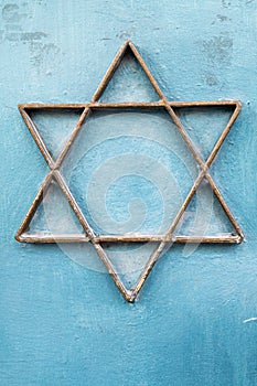 A Jewish star made from metal strips and mounted to a blue, metal door