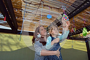 Jewish woman and child decorating their family Sukkah