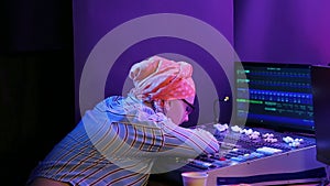 Jewish woman in a headscarf lighting designer programs light for show tired at work