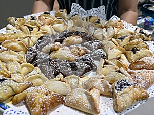 Jewish woman holding a large tray with many Purim jewish holiday cookies