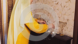 A Jewish woman lights candles on the eve of Pesach, which coincides with Saturday