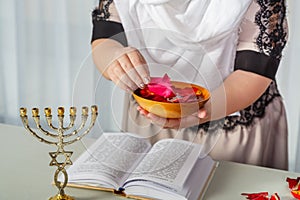 A Jewish woman performs superstition conspiracies before the wedding with rose petals to be the most beautiful for her