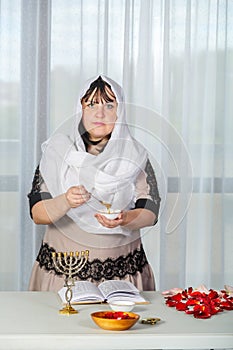 A Jewish woman in a white headscarf makes superstitious conspiracies before the wedding with honey in order to be
