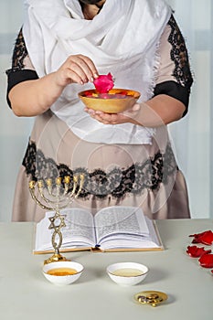 A Jewish woman in a white headscarf performs superstitious conspiracies before the wedding with rose petals to be the