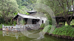 Jiangwan in Wuyuan County, Jiangxi Province, China. Old building in a garden with trees and a pond.