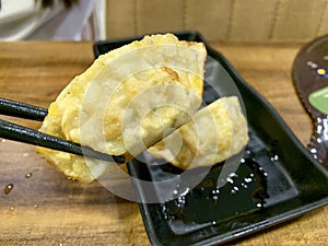 Jiaozi on black bowl with sauce photo