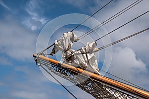 Jib boom with reefed sails on the bow of a historic sailing ship