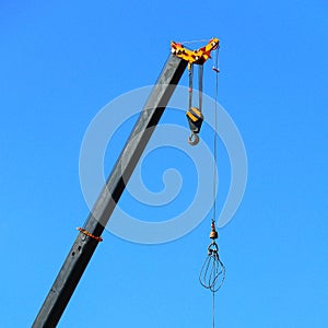 Jib of a construction crane during the daytime against a blue sky.