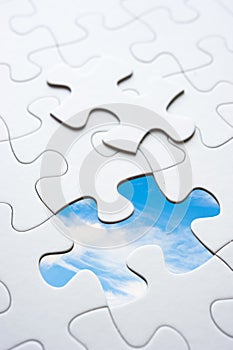 Jigsaw piece with sky in hole, conceptual image