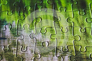 Jigsaw puzzle. Closeup of green jigsaw puzzle peices. Conceptual photo with focus on completed puzzle