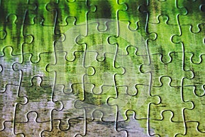 Jigsaw puzzle. Closeup of green jigsaw puzzle peices. Conceptual photo with focus on completed puzzle