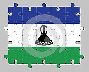 Jigsaw puzzle of Lesotho flag in blue white and green with a black mokorotlo a Basotho hat. photo