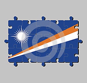 Jigsaw puzzle of Marshall Islands flag in blue field with two diagonal stripes of orange and white and the large white star.
