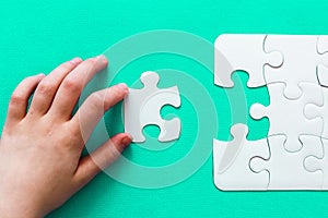Jigsaw Puzzle with missing piece on mint background People hand