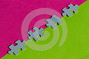 Jigsaw Puzzle pieces on border between pink and green background