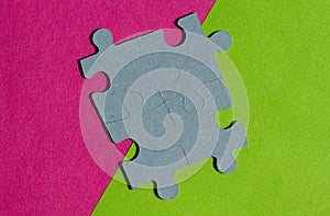 Jigsaw Puzzle pieces on border between pink and green background