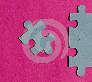 Jigsaw puzzle pieces on bright pink background