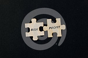 Jigsaw puzzle pieces with word Risk Profit isolated on black background