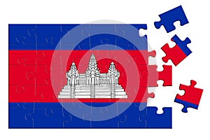 A jigsaw puzzle with a print of the flag of Cambodia, some pieces of the puzzle are scattered or disconnected. Isolated background