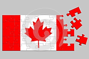 A jigsaw puzzle with a print of the flag of Canada, some pieces of the puzzle are scattered or disconnected. Isolated background.