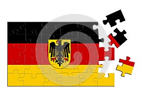 A jigsaw puzzle with a print of the flag of Germany, some pieces of the puzzle are scattered or disconnected. Isolated background