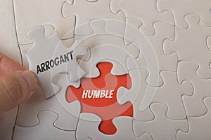 Jigsaw puzzle with text ARROGANT and HUMBLE