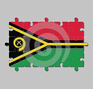 Jigsaw puzzle of Vanuatu flag in red and green with black and yellow color boar`s tusk encircling two crossed fern fronds.