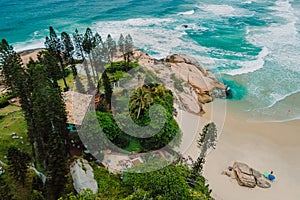 Joaquina beach with evergreen trees and ocean with waves in Florianopolis, Brazil. Aerial view photo