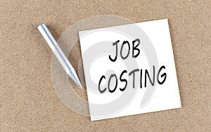 JOB COSTING text on sticky note on a cork board with pencil