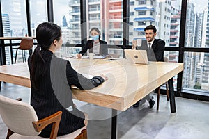 Job interview of caucasian human resource employer with secretary and young asian woman applicant in modern office