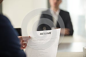 Job interview in office, focus on resume, close up view
