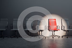 Job interview, recruitment concept. Row of chairs with one odd one out. Job opportunity. Red chair in spotlight.