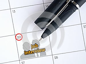 Job interview text and pen on calendar for reminder date. Business Concept.