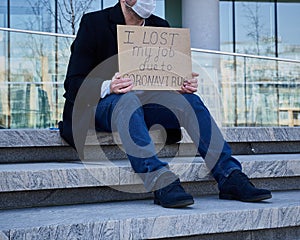 Job loss due to COVID-19 virus pandemic concept. Unrecognizable man holds sign