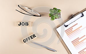 JOB OFFER text on wooden block with chart and glasses, business concept