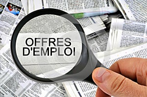 Job offers written in French studied with a magnifying glass