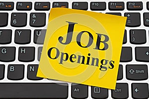 Job Openings message on yellow sticky note on a keyboard