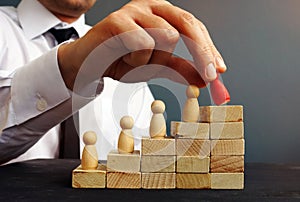 Job Promotion. Manager is holding figurine near career ladder. photo