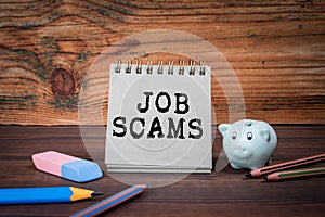 Job Scams. Cardboard notepad on wooden texture table