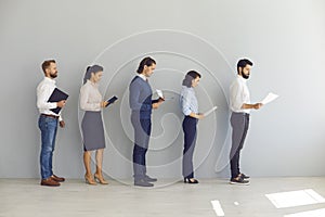 Job seekers applicants for vacancy standing in line with resumes and waiting for interview