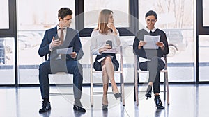 job seekers with resumes sitting near