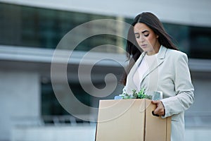 Jobless arabic businesswoman unhappily walking away office carrying belongings box