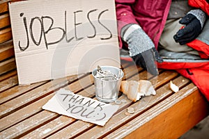 Jobless beggar begging money with cardboard and cup