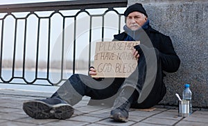 Jobless elderly man sitting on the cardboard box
